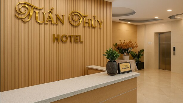 Una recepción de hotel con un panel de pared de madera y un letrero que dice "Tuan Chuy Hotel".