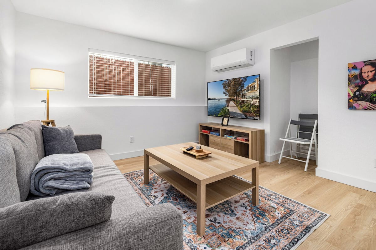 Un salon moderne avec un canapé, une table basse, un téléviseur et une échelle.