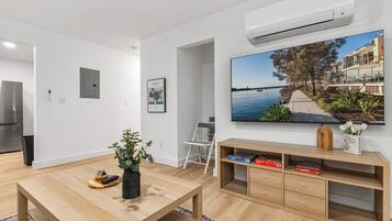 Design Apartment, City View | Living area | 65-inch Smart TV with digital channels, streaming services