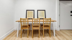 A dining area with a wooden table and chairs, framed documents on the wall, and a white door in the background. - Casitas en Pueblo - Central Lofts (Pueblo)