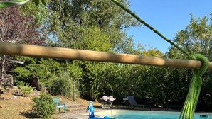 A hammock over a pool with a floating toy and lounge chairs in the background. - 2 Bedroom Cottage - Sleeps 6 - Pool - Garden (Caylus)