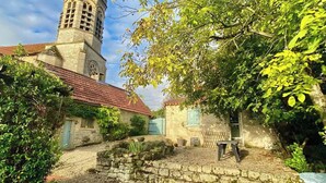 A stone church with a bell tower, surrounded by greenery and a gravel path. - 2 Bedroom Cottage - Sleeps 6 - Pool - Garden (Caylus)