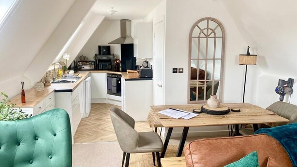 A compact living space with a kitchenette, a dining area, and a seating area with a sofa and chairs. - Central Tenby 3 Bed Apt Sleeps 6 to 8 Dog Friendly (Pembrokeshire)