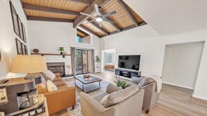 A spacious living room with a fireplace, a television, and a coffee table.