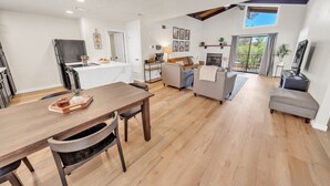 A spacious living area with a dining table, a sofa, and a TV.
