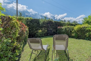 Two chairs facing a grassy area with a mountain backdrop.