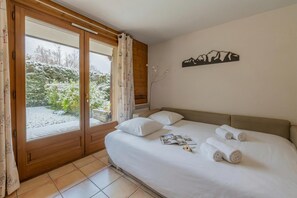 Una camera da letto con un letto, cuscini, una rivista e asciugamani.