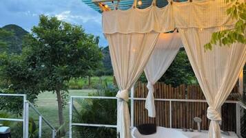 A spa area with a hot tub, surrounded by a wooden fence and greenery.