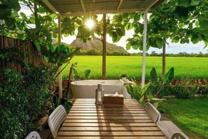 A wooden deck with a table, chairs, and a bathtub. - Khao Poon Camping (Kanchanaburi)