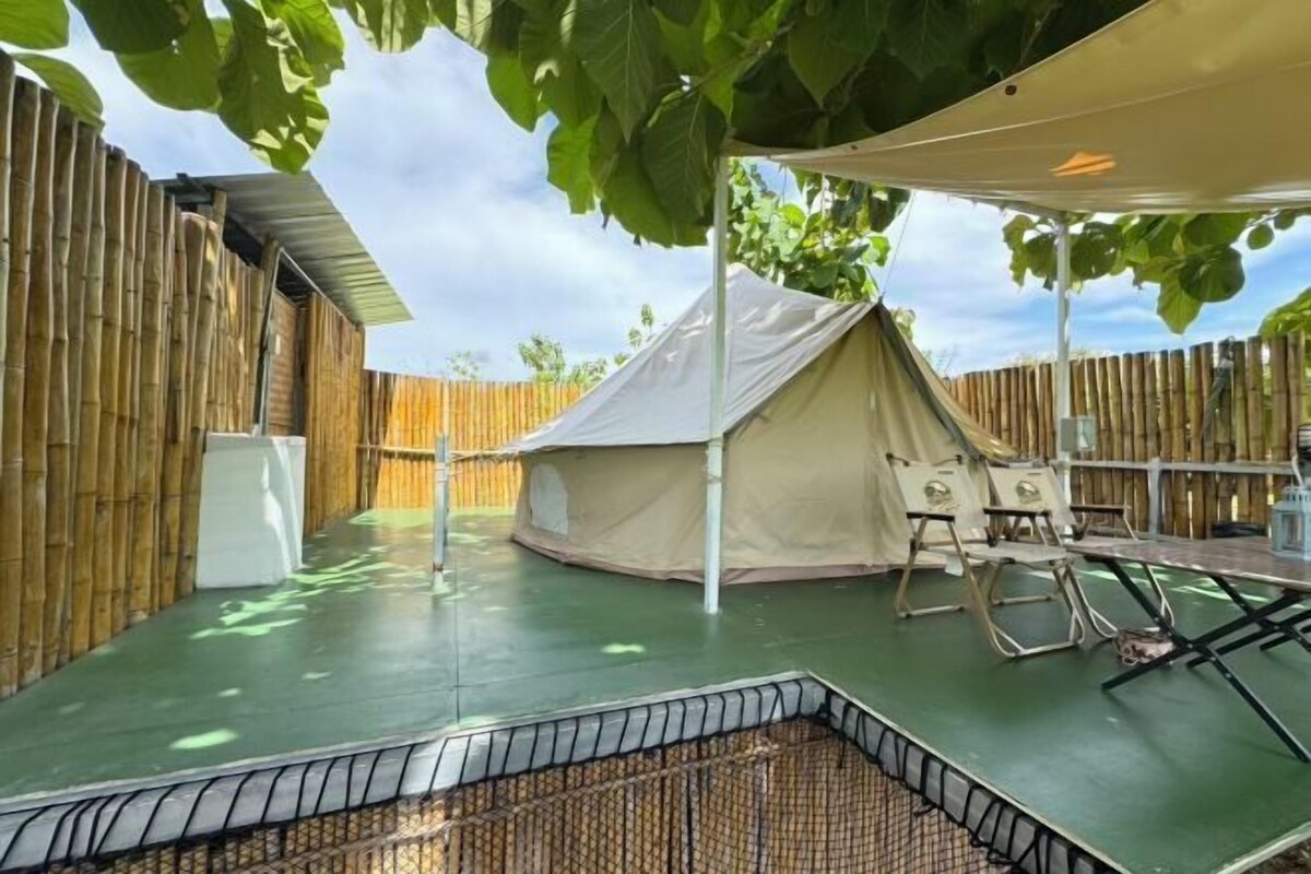 Un'area esterna coperta con una tenda, un tavolo e delle sedie.