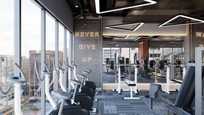 A gym with exercise equipment, large windows, and motivational wall text. - Bcons City Hotel (Ho Chi Minh City)