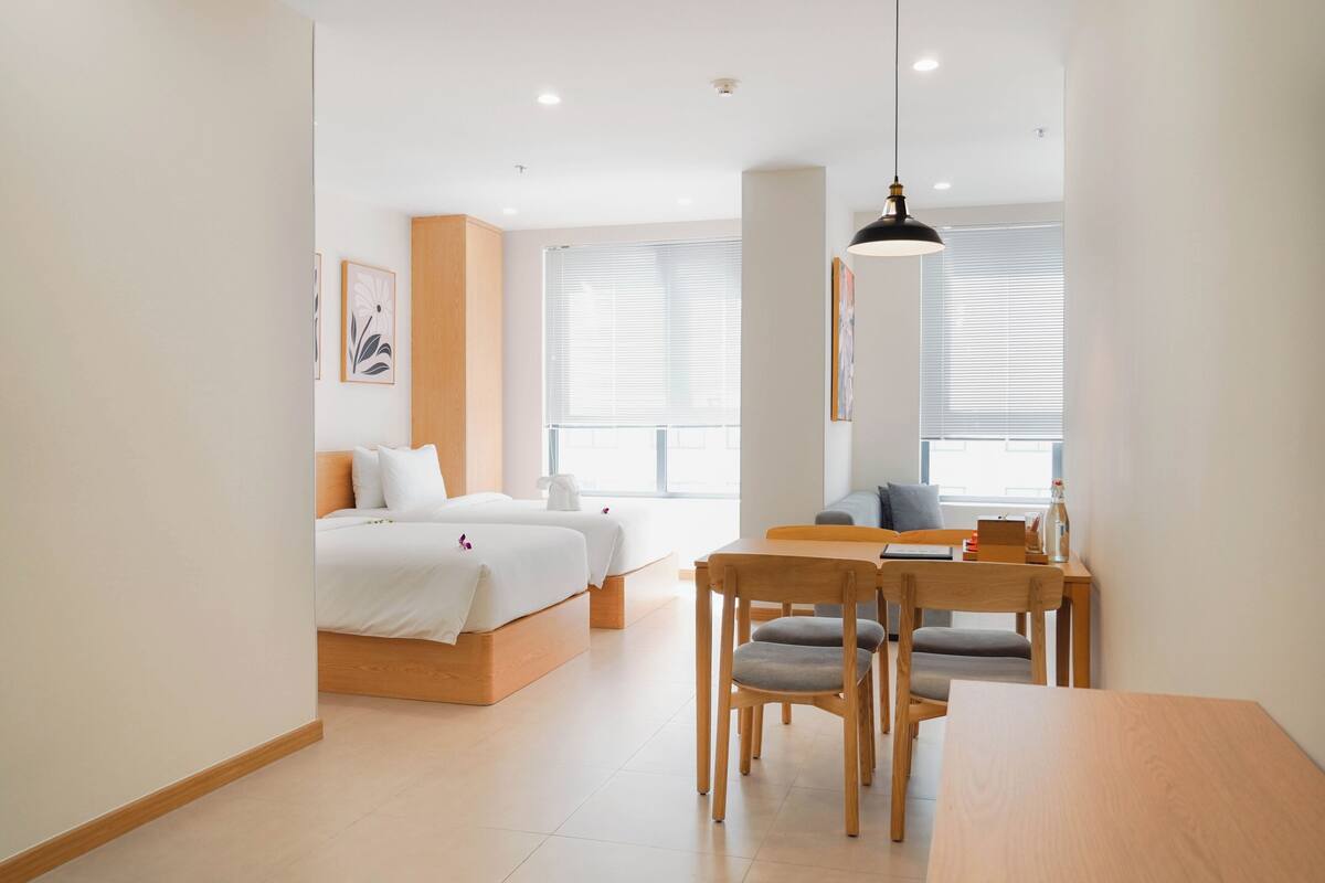 A modern hotel room with a bed, a desk, and a chair.