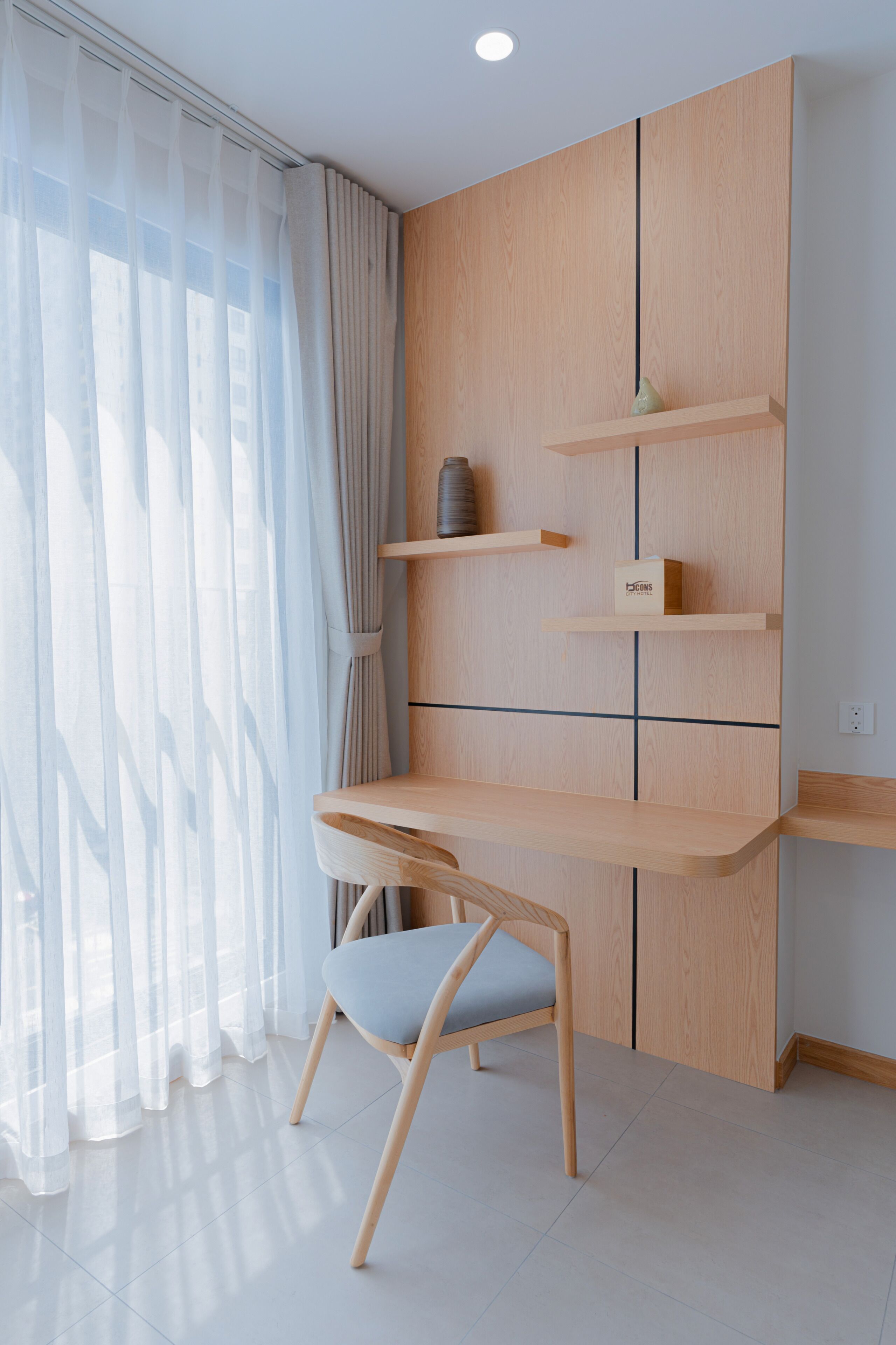Una habitación moderna con un escritorio de madera, una silla y estantes empotrados.