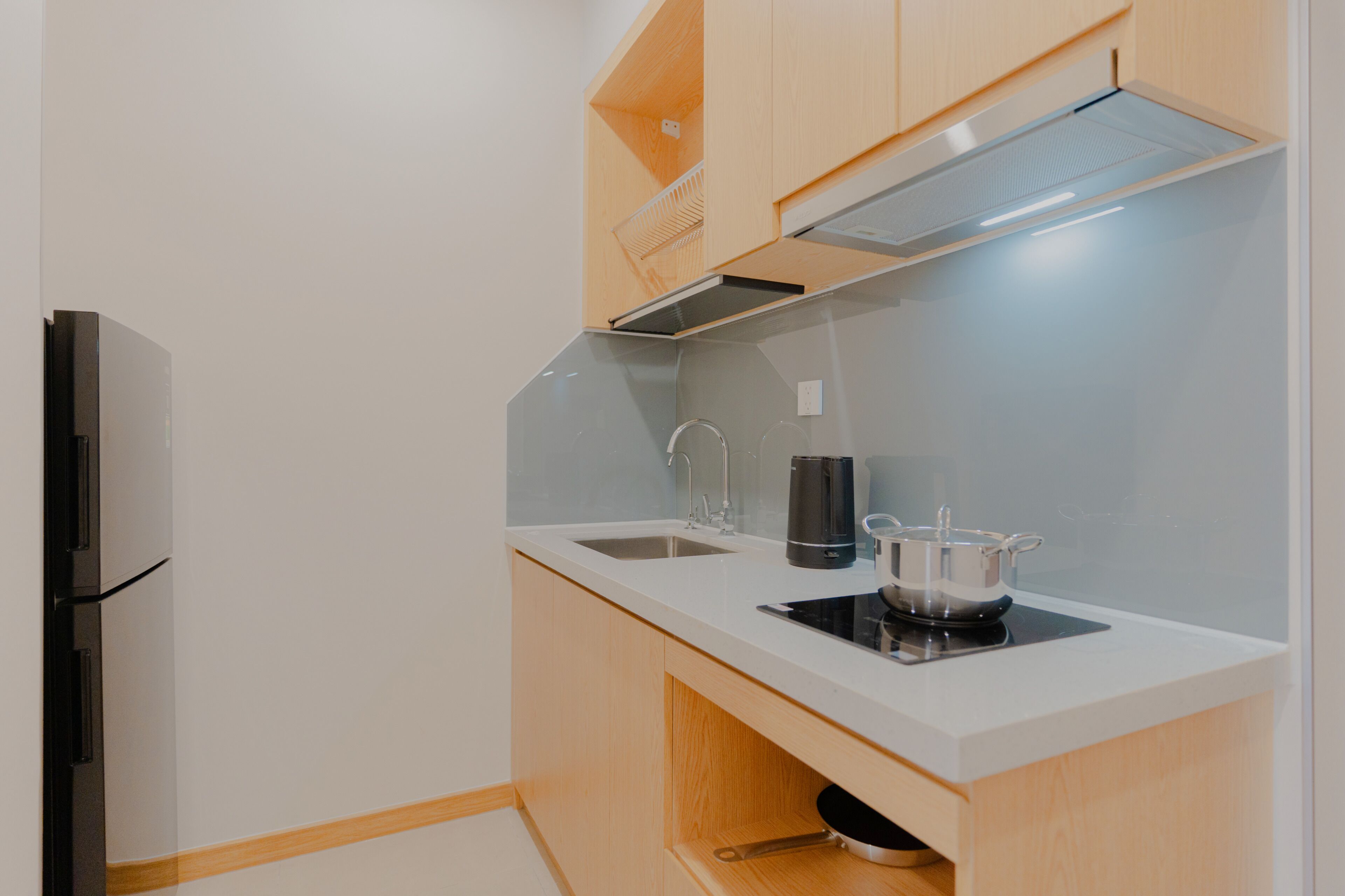 A compact kitchen with a built-in stove, a sink, and wooden cabinets.