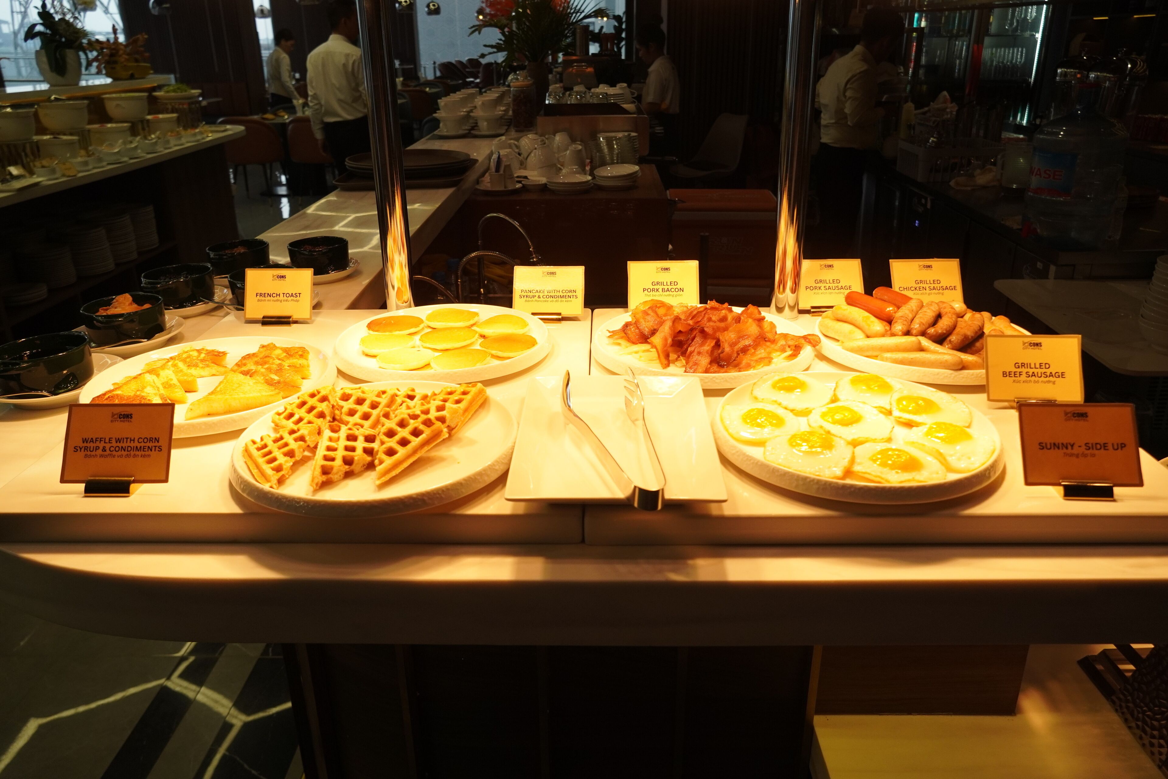 A buffet with various breakfast items including waffles, toast, and eggs.