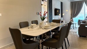 Un comedor moderno con una mesa larga, sillas y un florero con flores.