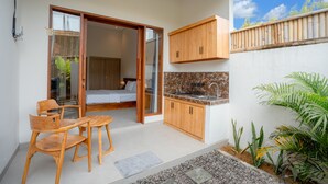 Une cuisine compacte dotée de meubles en bois, d’un évier et d’un coin repas avec une table et des chaises.