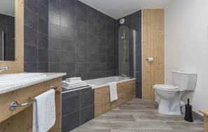 Une salle de bain moderne avec une baignoire, des toilettes et un lavabo.