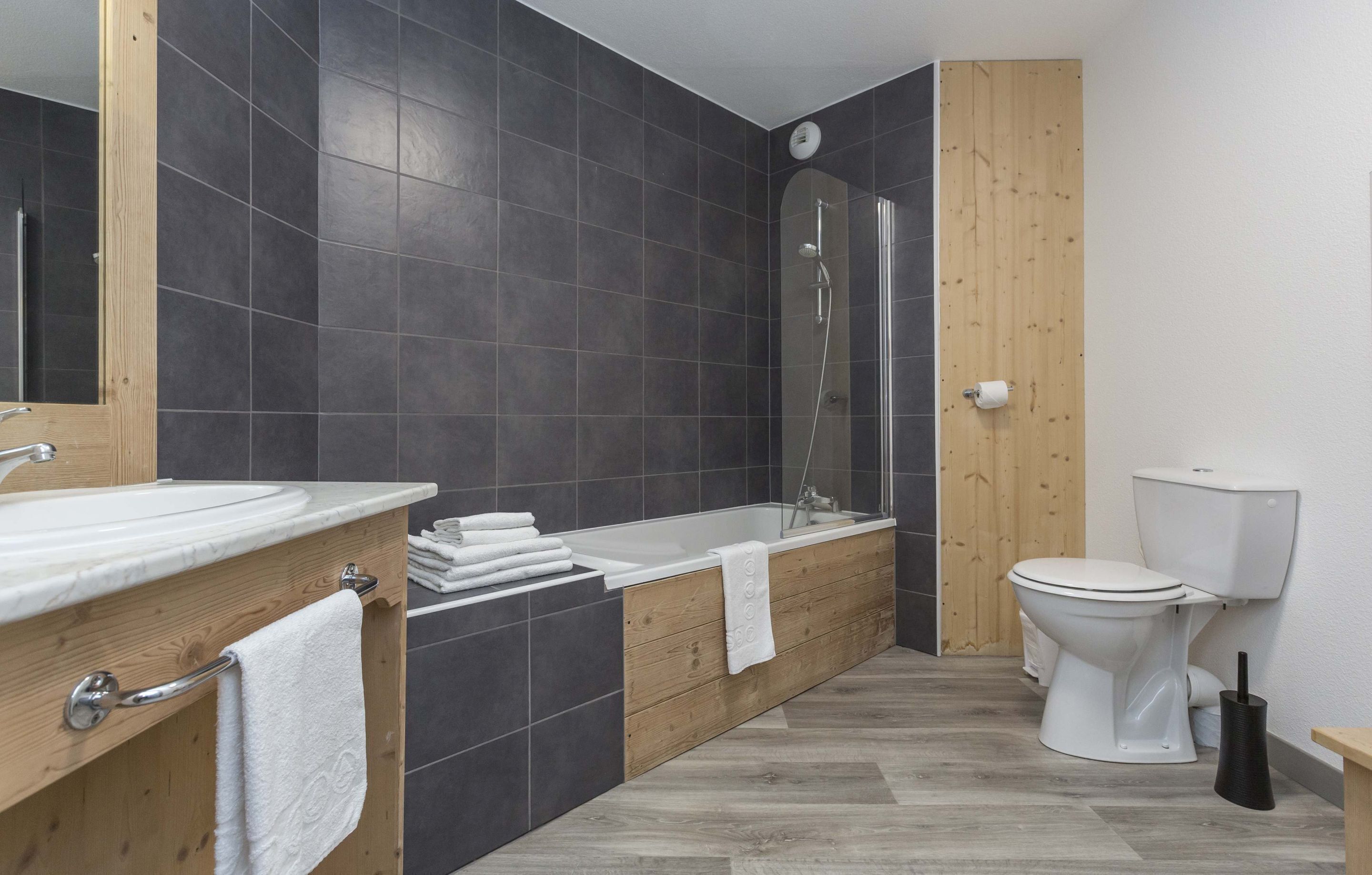 A modern bathroom with a bathtub, toilet, and sink.
