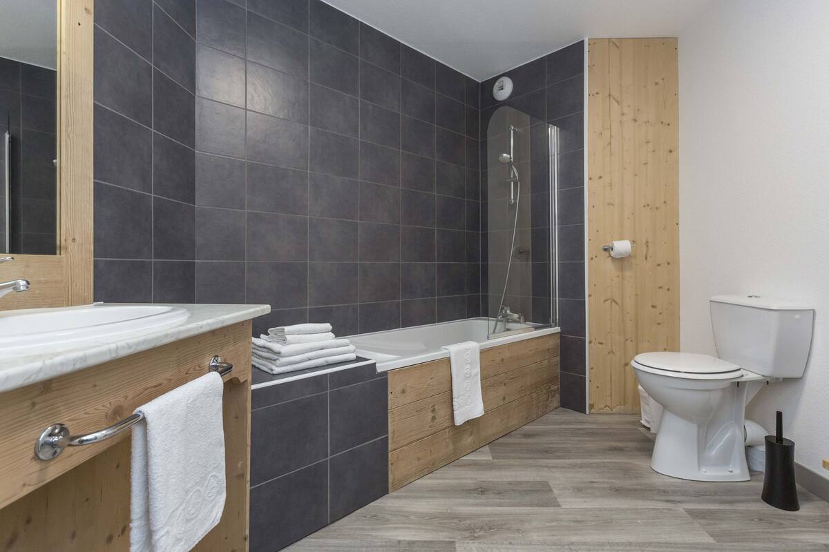 Un baño moderno con bañera, inodoro y lavamanos.