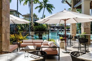 A poolside area with seating, umbrellas, and a view of the pool.