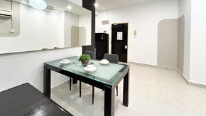 A modern conference room with a glass table, chairs, and a potted plant.