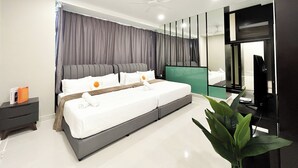 A modern bedroom with a large bed, grey curtains, a ceiling fan, a bedside table, and a large mirror.