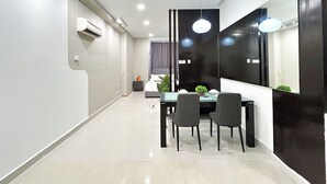 A modern hotel room with a dining area, a large mirror, and a bed with a window.