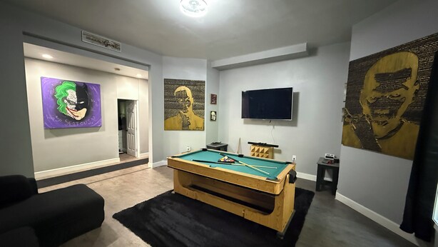 A room with a pool table, a television, and artwork on the walls. - Spacious 2BR Full Kitchen Suite + Pool Table I
Patio + Private (Lawrenceville)