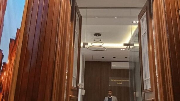 The entrance of a hotel with a wooden facade and a sign indicating it is the Newpanorama Inn Hotel. - New Panorama Inn (Cairo)