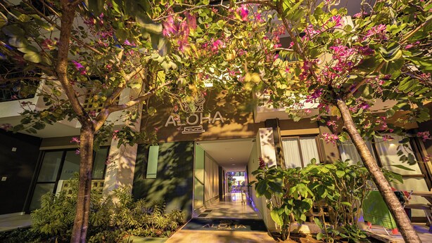 A building entrance with a sign reading "ALOHA" and a pathway leading to the entrance. - Cozy home with Wi-Fi, air conditioning and great location in Muro Alto/PE (Ipojuca)