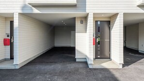 A modern building with a covered outdoor area, a door with a glass panel, and a red mailbox. - FURANO RESORT WAKABA D (Furano)