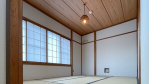 A traditional Japanese room with tatami flooring, wooden beams, and a large shoji screen window. - Izu-Kogen Tent Resort (Ito)