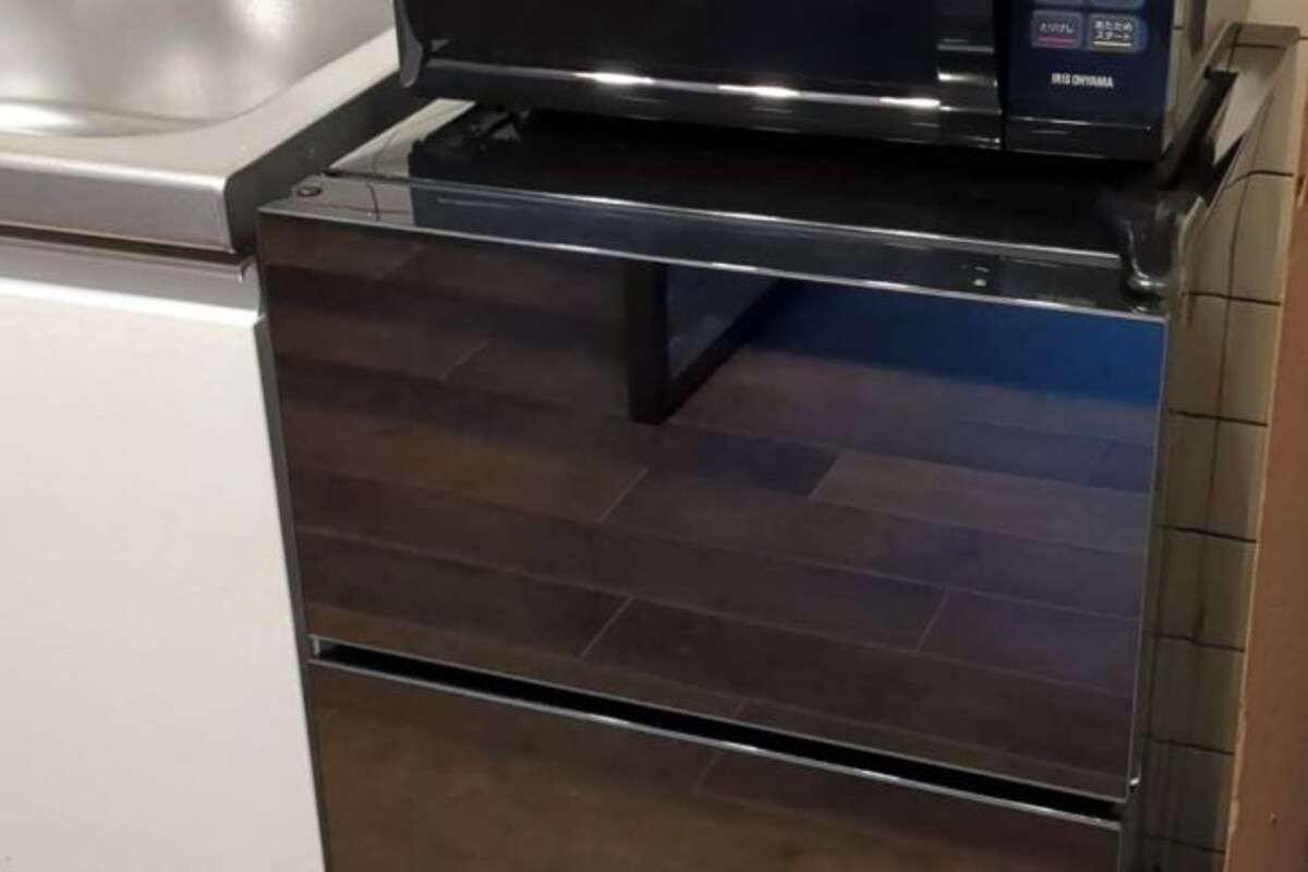 Una cocina con horno y microondas de acero inoxidable.