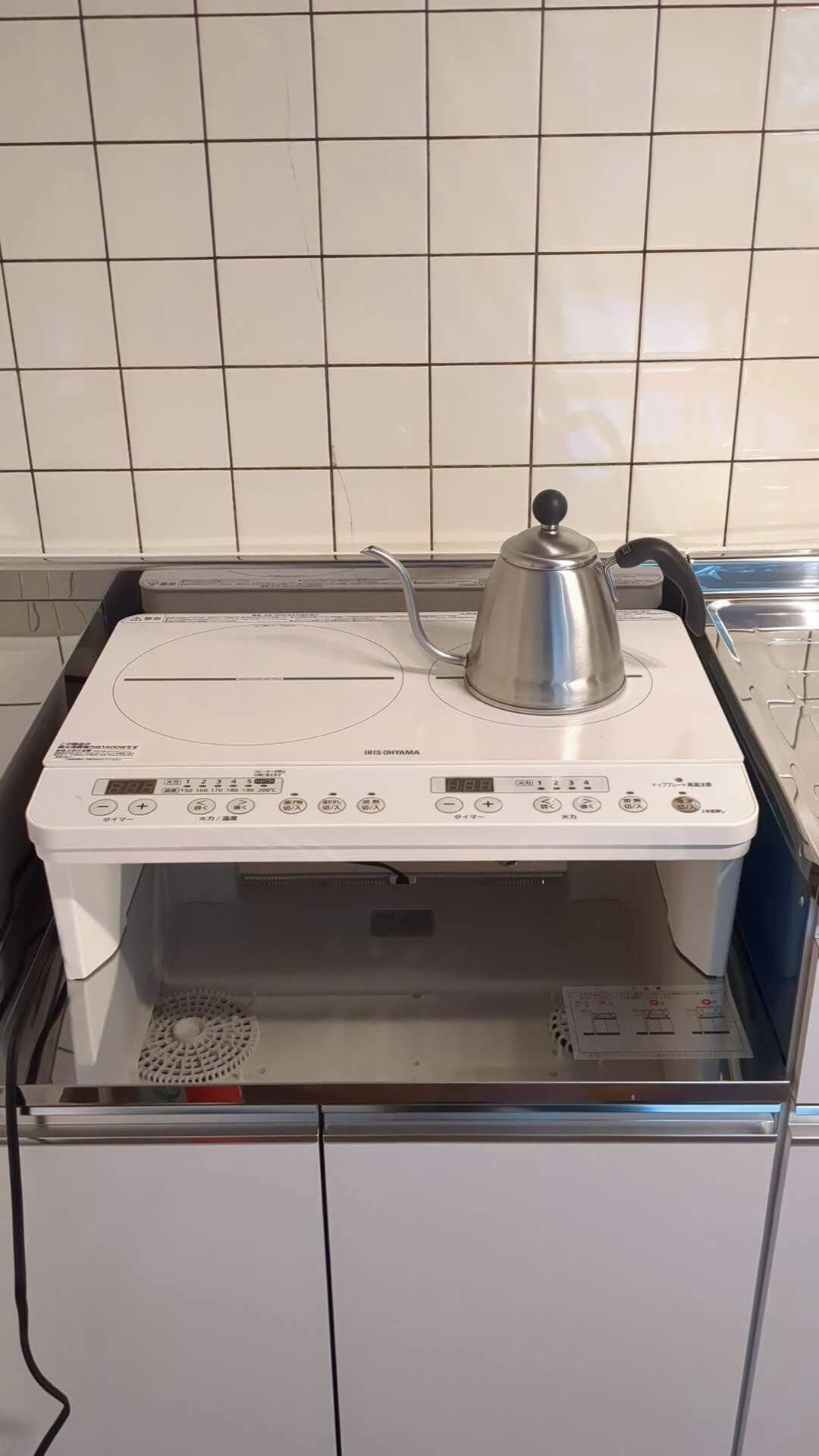 Eine Küche mit eingebauter Elektroherd und Wasserkocher darauf.