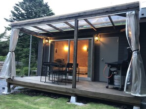 A covered outdoor area with a table and chairs, a grill, and a gas cylinder. - IZUKOGEN TENT RESORT (Ito)