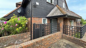 Une maison à deux étages avec une façade en briques et un toit noir.