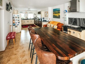 Une cuisine moderne avec une table à manger en bois, des chaises et un four encastré.