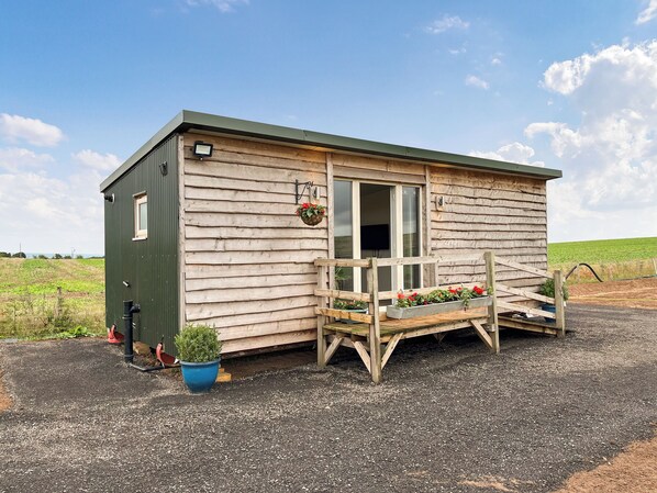 Eine kleine Holzhütte mit Veranda, Fenster und Tür.