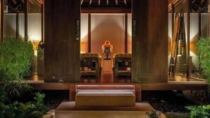 A reception area with a wooden ceiling, two seating areas, and a central light fixture.