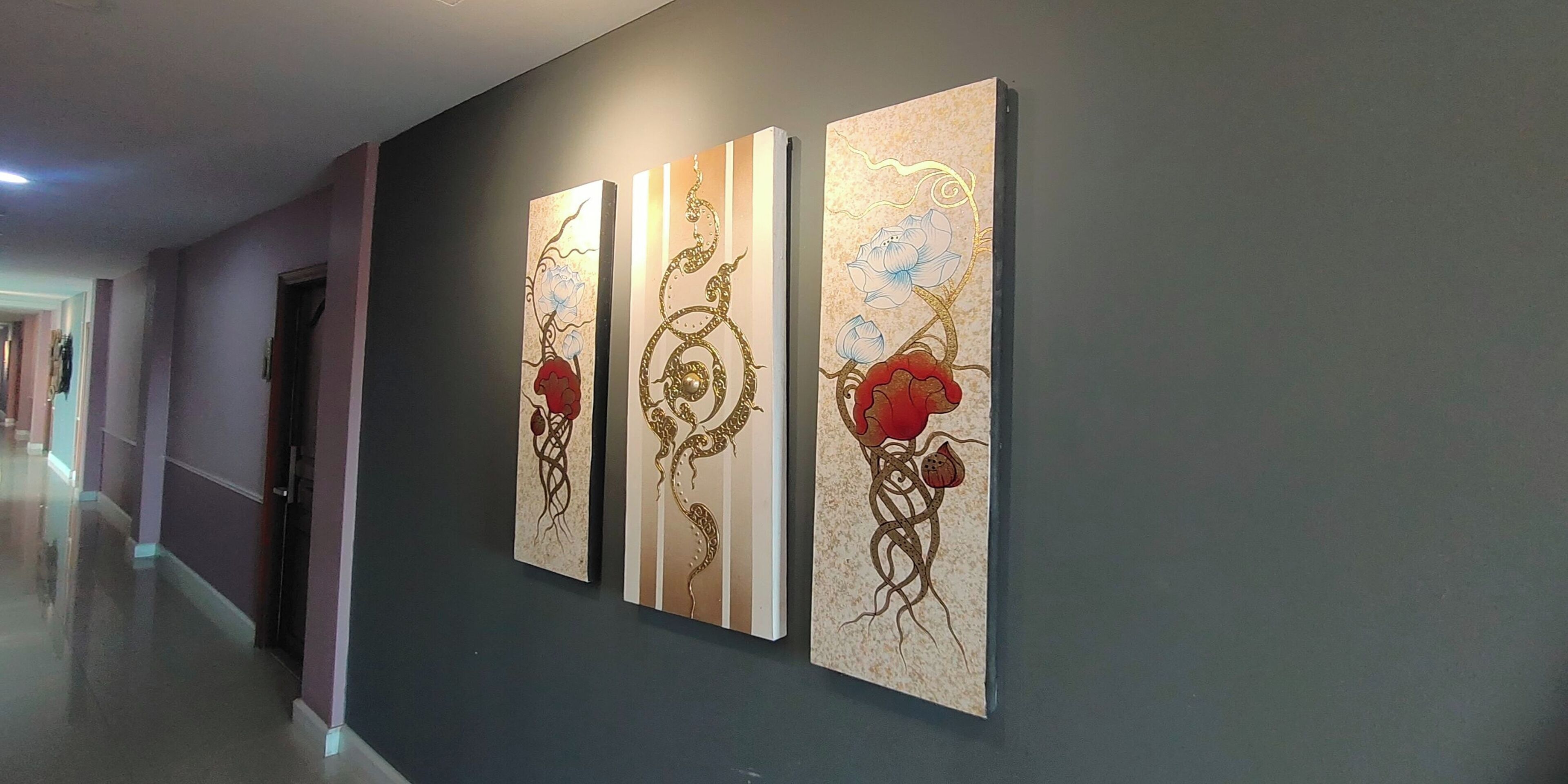 A hallway with three vertical artworks on the wall.