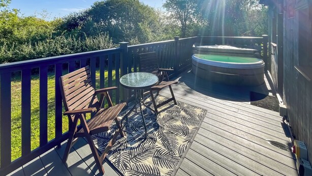 A wooden deck with a hot tub, a bench, and a table. - 3 bedroom accommodation in Brigg (Brigg)