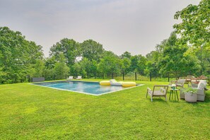 A backyard with a swimming pool, inflatable loungers, and outdoor furniture. - Hudson Valley Summer Escape w/ Pool & Fire Pit (Pine Plains)