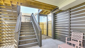 A covered outdoor area with a wooden staircase, a bench, and a chair. - 1 Mi to Galveston Beach, Seawall: New Tiny Home! (Galveston)