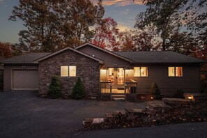 A two-story house with a stone facade, a front porch, and a garage.