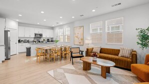 A modern living room with a sofa, coffee table, and dining area.