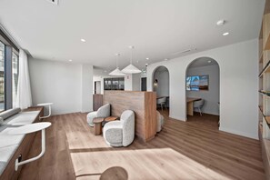 Un intérieur moderne comprenant un comptoir d’accueil, un espace salon et un coin repas.