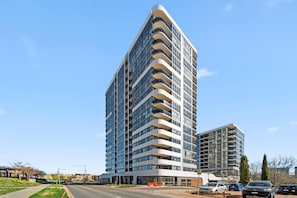 A multi-story building with a curved facade, large windows, and balconies.