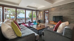 A modern living room with a large sofa, a coffee table, and a television.