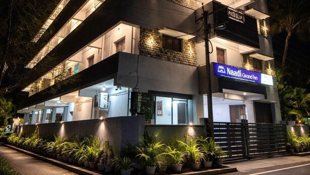A multi-story hotel with a modern design, featuring a prominent signage for 'Nadi Grand Inn' and a well-lit entrance.